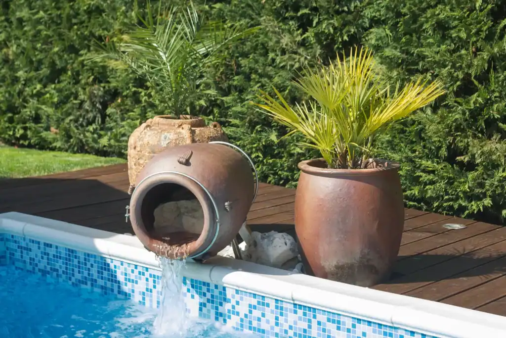 Pool der Villa Santa Domenica mit Wasserspeier-Amphore und Palmen in Töpfen
