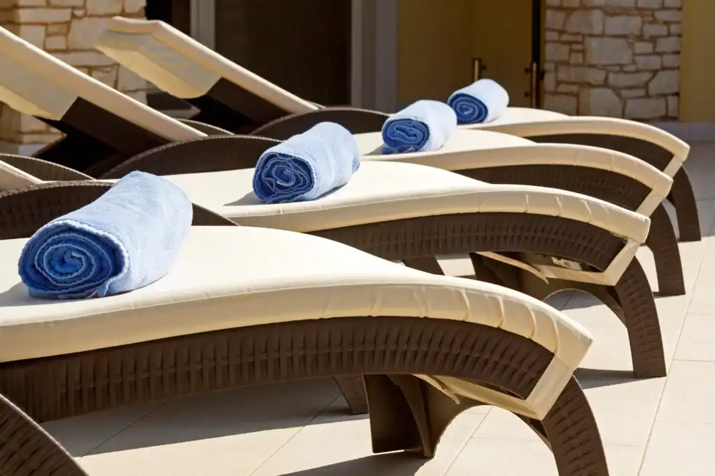 Terrasse der Villa Santa Domenica mit Sonnenliegen und gerollten blauen Handtüchern