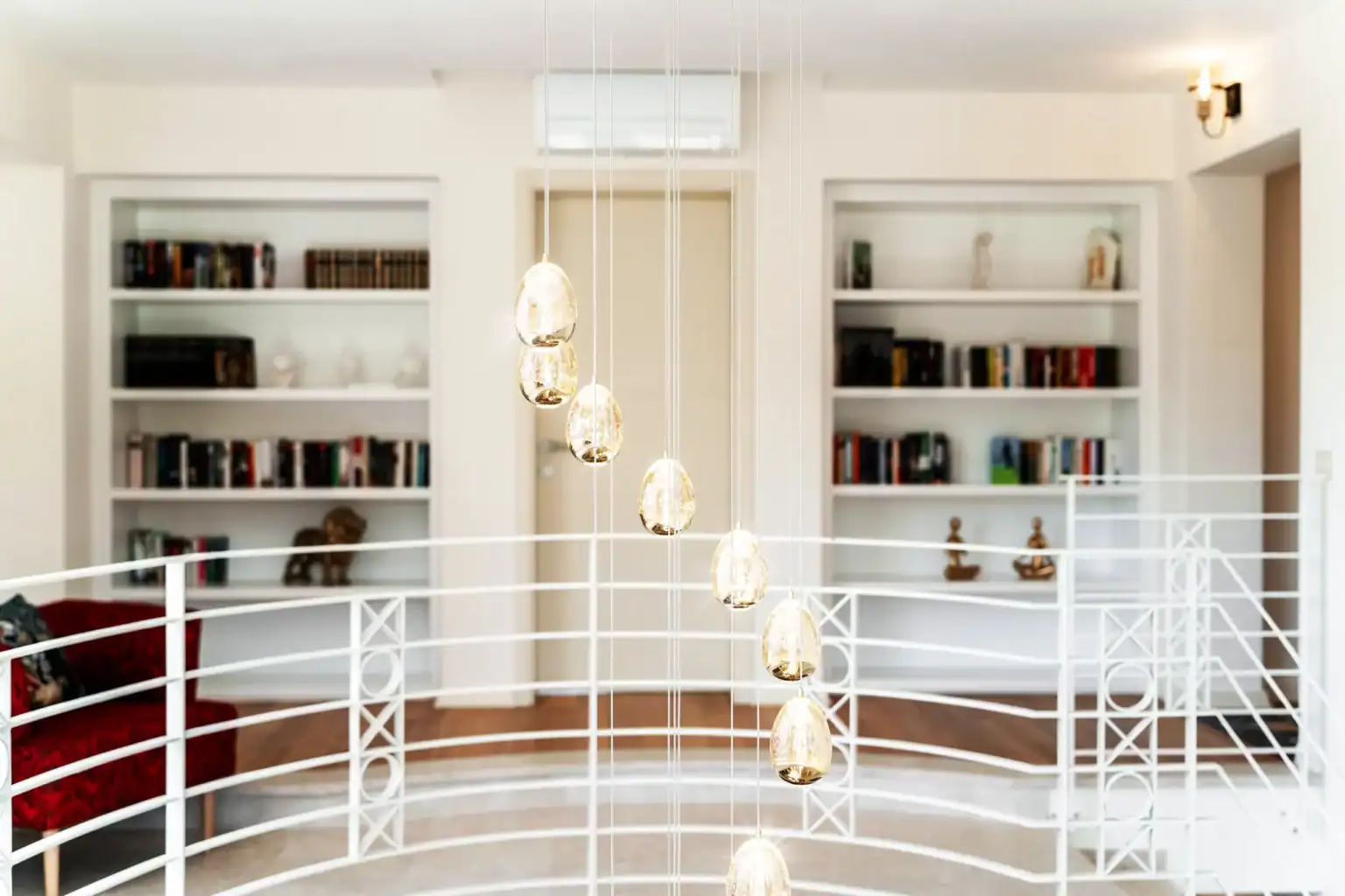 Villa Lionea 50 Galerie der Villa Lionea mit Bücherregalen, Glasleuchten und weißem Geländer