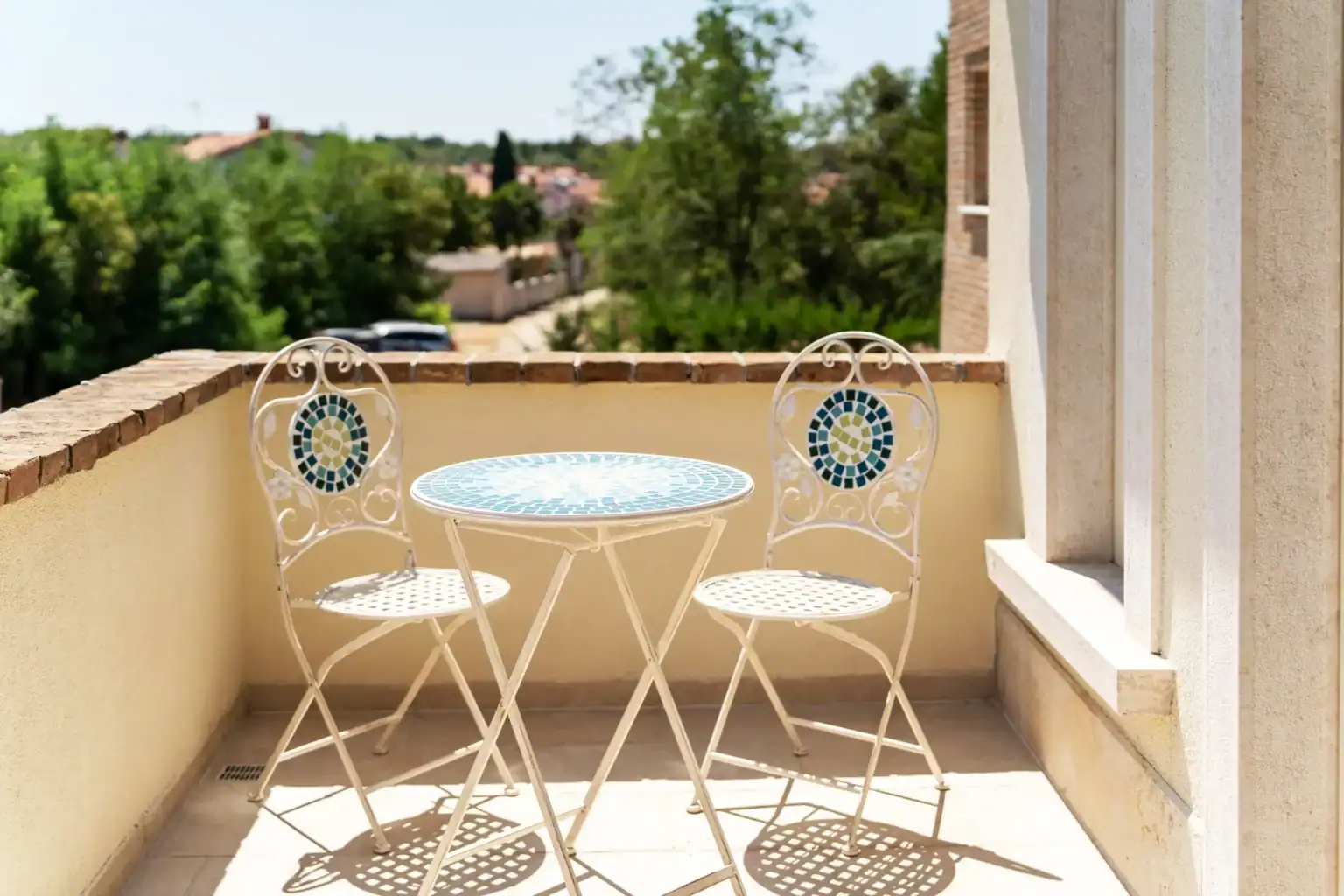Villa Lionea 49 Balkon der Villa Lionea mit Mosaiktisch und zwei weißen Bistrostühlen