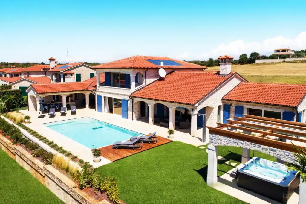 Außenansicht der Villa Kastelir von oben mit Pool, Rasen und Pergola