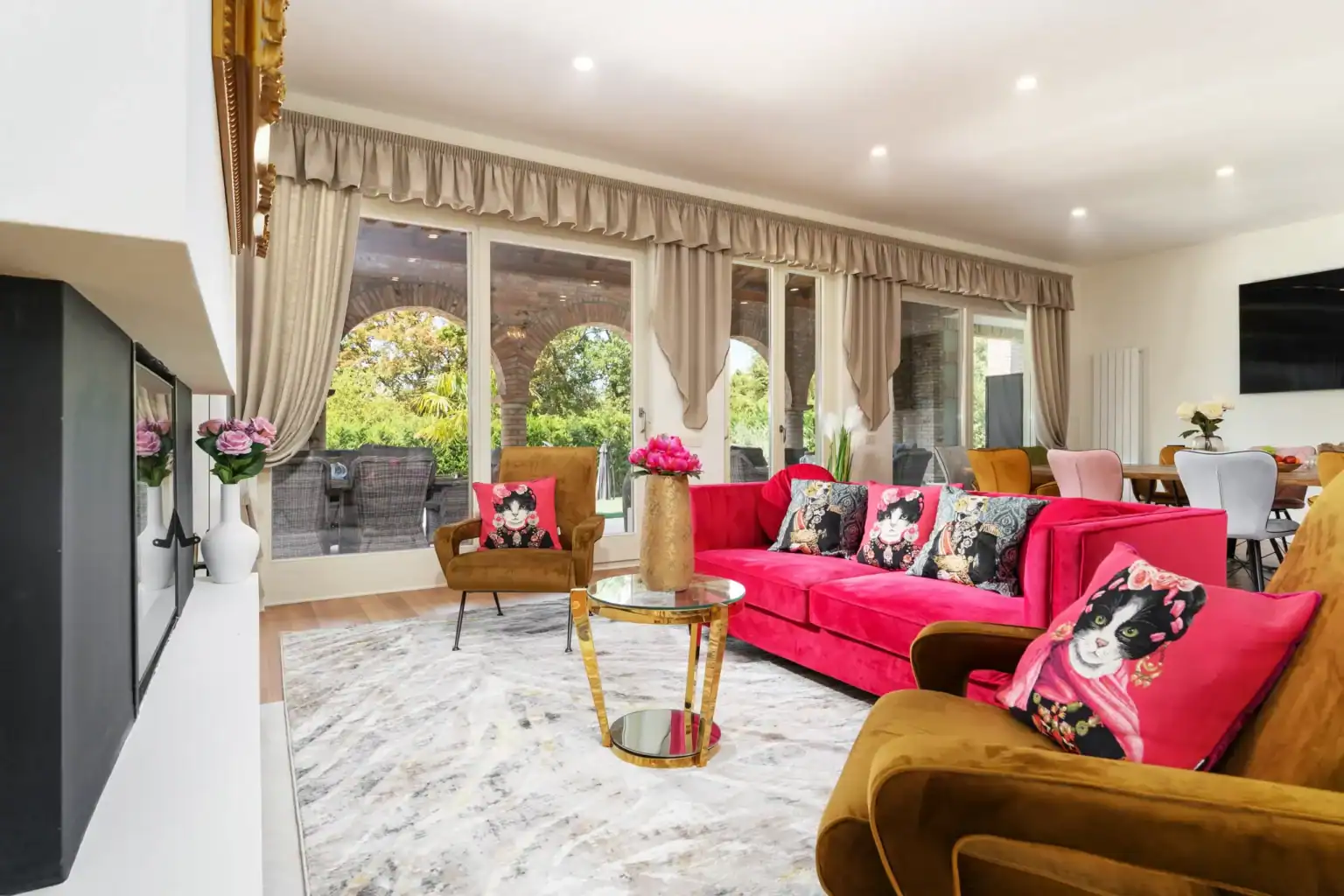 Villa Lionea 42 Wohnzimmer der Villa Lionea mit pinkfarbenem Sofa und Blick zur Bogenterrasse