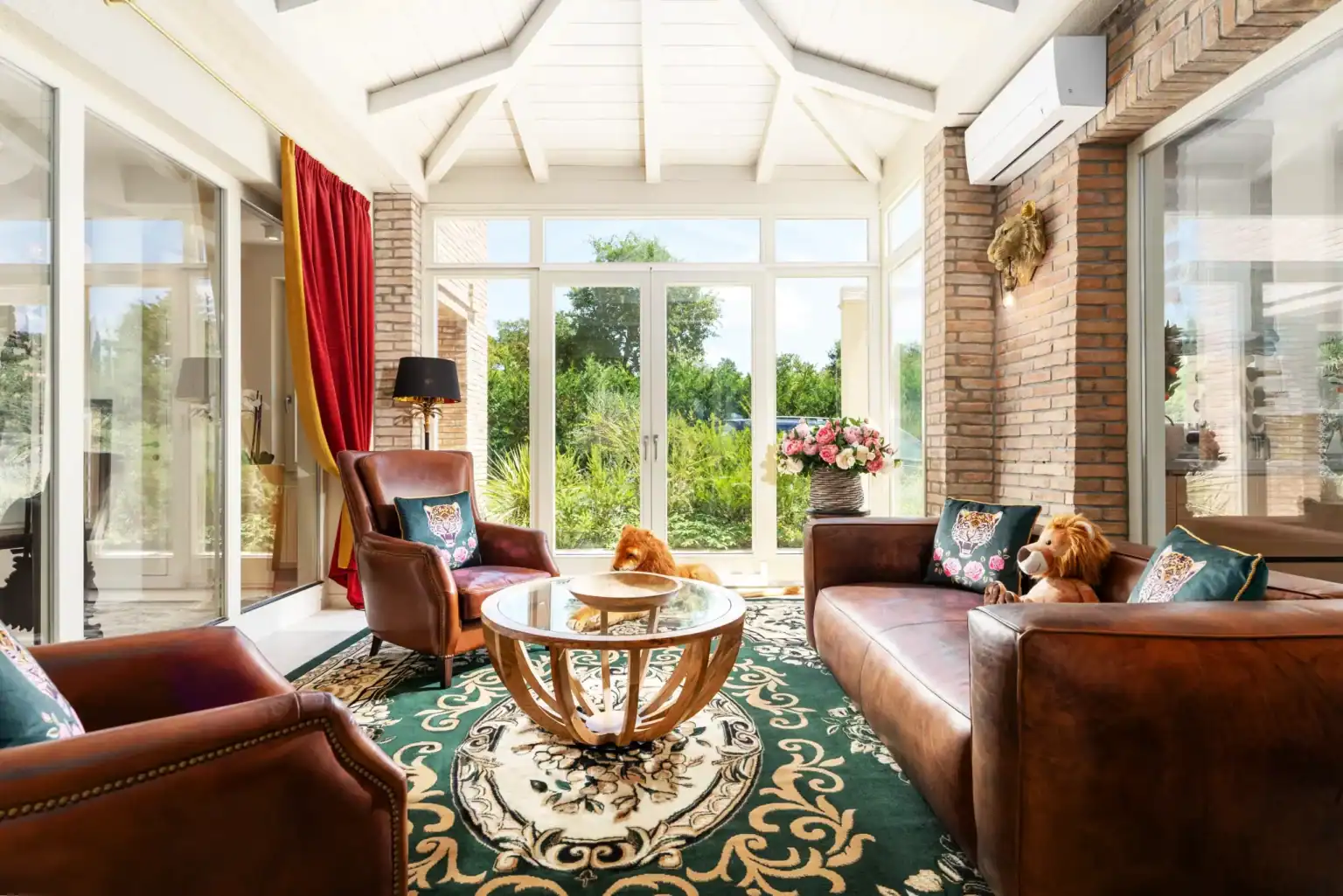 Villa Lionea 38 Wintergarten der Villa Lionea mit braunen Ledersofas und grünem Teppich