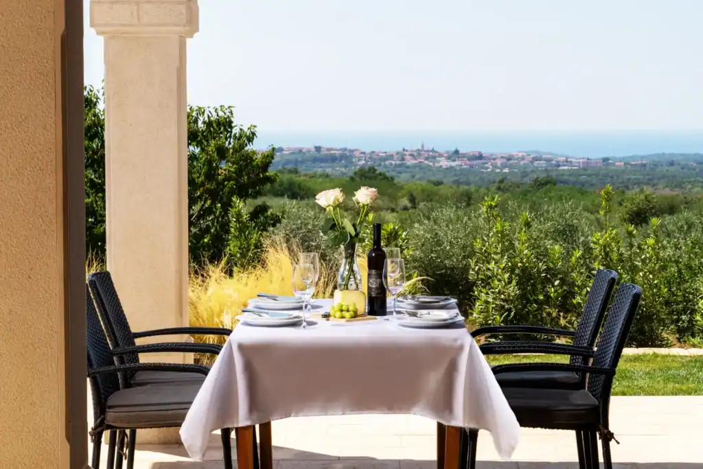 Terrasse der Villa Kastelir mit weiß gedecktem Tisch und Meerblick am Horizont