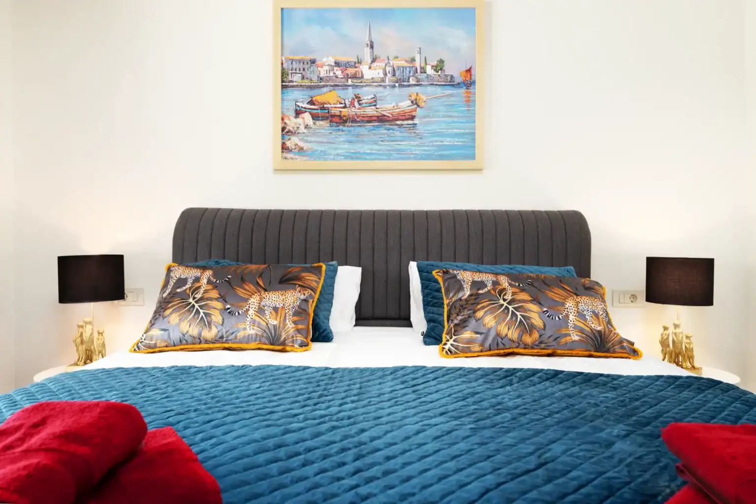 Villa Lionea 32 Doppelbett der Villa Lionea mit blauem Überwurf und Hafengemälde