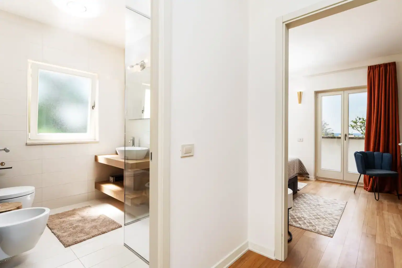 Villa Lionea 9 Badezimmer der Villa Lionea mit Aufsatzwaschbecken und Blick ins Schlafzimmer